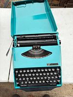 Typewriter fully opened showing lid, platen, keyboard