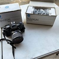 Camera and lens with original boxes visible