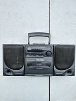 Front view showing speakers, tuner, cassette deck, brand and model