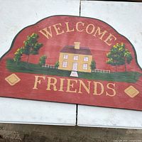Overall view of painted wooden sign showing text, graphic and shape