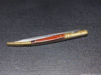 Knife closed showing brass bolsters and wood inlay handle