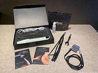 Neon Wand set in open box with accessories, booklets and iStim items displayed