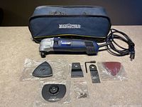 Complete set including tool, accessories, and bag laid out