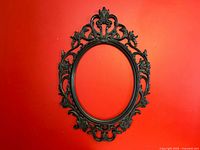 Full view of ornate black plastic oval frame