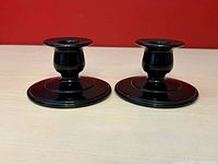 Front view of both amethyst glass candlestick holders