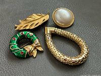 Four jewelry pieces arranged on leather surface