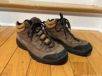 oblique front view of both boots showing uppers, laces, toe caps, and tread profile