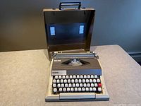 Typewriter seated inside open hard case showing keyboard and interior
