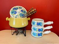 full set showing pot on stand, forks, three bowls