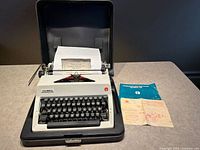 Typewriter in open case with manuals visible