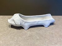 Full side view of white porcelain pig-shaped server showing overall form and recessed well