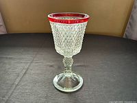 Full view of clear pressed glass goblet vase with ruby rim