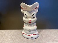 Front view of Shawnee pig creamer showing facial features and dress details