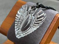 Close-up of starburst-cut crystal heart pendant on display pillow