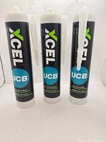 Three Xcel adhesive cartridges standing upright