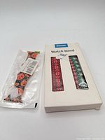 Bogeer box containing two Christmas patterned bands and separate sealed Halloween pumpkin band