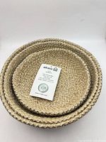 Nested view of all three Alkaso jute baskets with tag visible