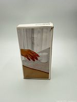 Opposite side of box with illustrative use photo showing device in hand