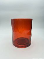 Front view of orange-red glass hurricane candle holder