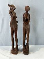 Front view of both wooden figures standing side by side