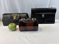 All three handbags side by side with size reference apple