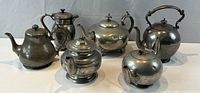 Front group view of all six pewter teapots