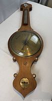 Full view of antique wooden banjo barometer laying flat
