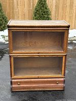 Front view showing two glass-front sections and drawer base