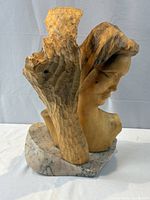 Front-left view of carved wood bust on stone base