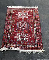 Full view of red hand knotted rug with fringe