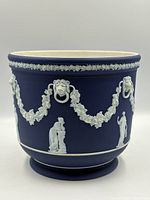 Full view of jardiniere exterior showing figures, garlands, lion masks