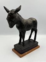 three-quarter view of full bronze mule sculpture on wood base