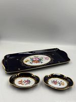 Front view of all three porcelain pieces showing cobalt glaze, floral centers, gilt rims