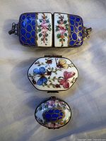 Three porcelain trinket boxes stacked closed, showing size comparison