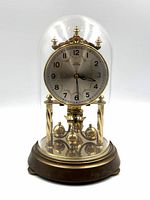 Front view showing dial, pendulum and glass dome