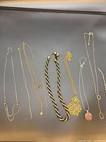 All ten jewellery items laid out to display type, pendants and condition