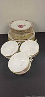 Stack of plates with cups and saucers displayed