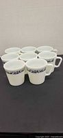 Eight matching Pyrex Cornflower Blue mugs grouped together