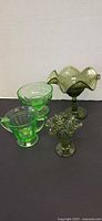 Group shot of all four green pressed glass pieces