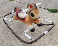 Angled view of tan blow-mold horse on spring frame