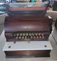 Front view showing wood case, key layout, porcelain shelf