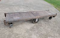 Full view of rectangular wood and metal cart on concrete surface
