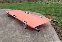 Top view of unfolded orange folding stretcher on ground