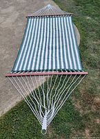 Full view of hammock laid flat showing striped fabric, ropes, spreader bars