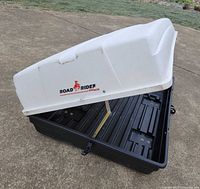 Lid raised on rooftop cargo box showing interior and latch