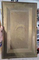 Front view of rectangular brass tray showing etched central panel and raised rim