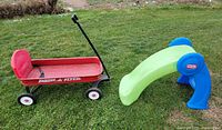Little Tikes slide and Radio Flyer wagon side by side on lawn