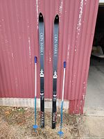 Full view of Olin Mark I skis and A&T poles leaning against wall