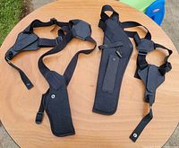 Both Uncle Mike's Sidekick holsters with harnesses displayed on table