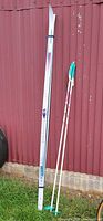 Full view of Karhu skis and Alpina poles leaning against wall